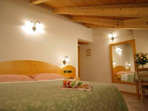 a bedroom with a bed with a tray of food on it at Jolly B&B - Affittacamere in Dimaro