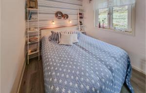 a bedroom with a blue bed with pillows on it at 2 Bedroom Lovely Apartment In Lysekil in Lysekil