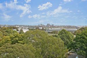 a view of a city with trees and a building at Aircabin｜Mascot｜Spacious & Modern｜Walk to station in Sydney