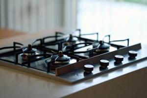 a stove top with four burners on a counter at オーシャンビュー非日常を味わえる空間プライベートバーベキューm yomitan nagahama in Yomitan +32 photos