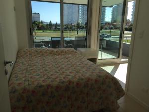 a bedroom with a bed and a large window at Torre del mar in Punta del Este