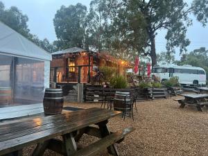 una mesa de picnic y un edificio con mesas y sillas en Cosy Glamping Tent 1, en Ararat