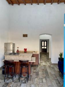 una cucina con bancone e sgabelli in una stanza di Departamento Frente a la Plaza Principal Jala a Jala