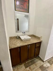 a bathroom with a sink and a mirror at Departamento Frente a la Plaza Principal Jala in Jala