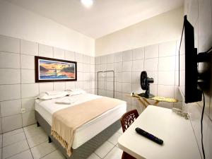um quarto com uma cama e uma secretária com um telefone em 202 Kitnet no centro com wifi em Aracaju