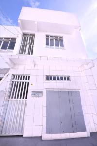 um edifício branco com uma porta ao lado em 202 Kitnet no centro com wifi em Aracaju