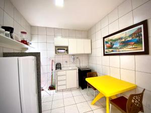 uma pequena cozinha com uma mesa amarela e um frigorífico em 202 Kitnet no centro com wifi em Aracaju