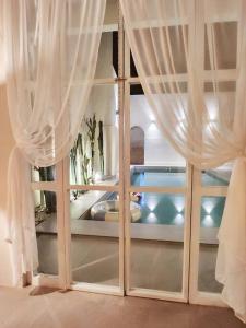 Maribagoにあるevening pool villaの白いカーテン付きの窓が備わる客室です。