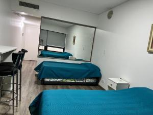 1 dormitorio con 2 camas y un espejo grande en Av. Corrientes 820, Obelisco II en Buenos Aires
