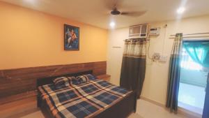 um quarto com uma cama, uma ventoinha e uma janela em Bhargava Ashram em Vrindavan