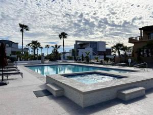 a large swimming pool in a resort with palm trees at Sandy Beach Costa Diamante House E10 Dog Friendly in Puerto Peñasco