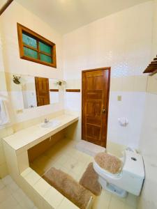 a bathroom with a toilet and a sink and a mirror at La Casa de Joel in Puerto Villamil