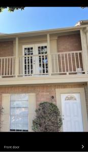 a large house with a white door and a balcony at 77072 New remodeled Cute Townhome SW in Houston