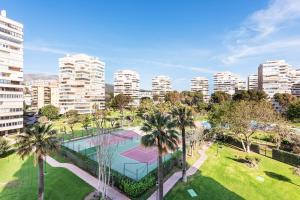 - une vue aérienne sur un court de tennis avec des palmiers et des bâtiments dans l'établissement Stay U-nique Apartment Playamar, à Torremolinos