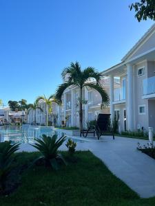 Villa con palmeras frente a un edificio en Casa em Arraial d'Ajuda, en Arraial d'Ajuda