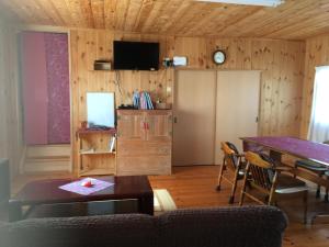 salon ze stołem i telewizorem w obiekcie MOMO HOUSE w mieście Inami