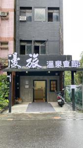 a building with asian writing on top of it at 漫旅溫泉會館-愛娜 in Jiaoxi