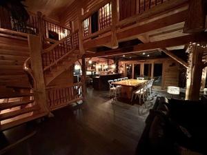 a large room with a wooden staircase and a table at BIGFOOT - Chalets de Môh - Jacuzzi in La Malbaie