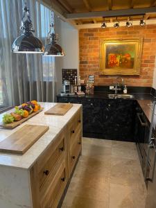 a kitchen with a sink and a counter with fruits on it at Executive Corporate Penthouse in Woking