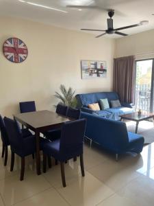a living room with a table and a blue couch at Awin swiss garden residence in Kuantan