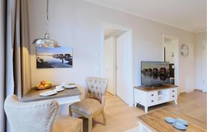 a living room with a table and chairs and a television at Baltischer Hof Apartment 36 in Boltenhagen