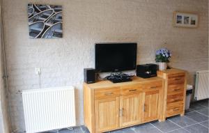 a television on a wooden dresser with speakers at Two-Bedroom Holiday Home In Callantsoog in Callantsoog