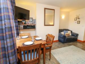 a dining room with a table and chairs and a couch at Hunter Cottage in Haltwhistle +20 photos