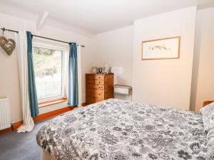 um quarto com uma cama e uma janela em Hunter Cottage em Haltwhistle