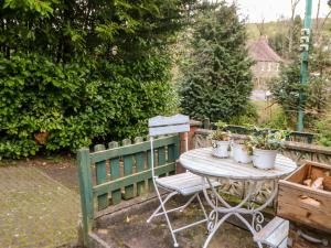 a table with potted plants on it next to a fence at Hunter Cottage in Haltwhistle
