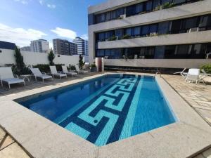 a swimming pool in front of a building at Pituba 1Q frente ao mar Ed Madison Plaza 100m da praia in Salvador