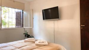 1 dormitorio con 1 cama y TV de pantalla plana en la pared en Departamento del Parque en San Salvador de Jujuy