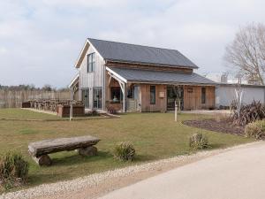 a wooden house with a bench in front of it at Muntjac Lodge in Somerford Keynes