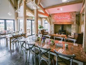a restaurant with tables and chairs and a fireplace at Muntjac Lodge in Somerford Keynes
