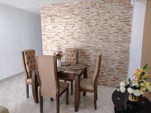 a dining room with a table and chairs and a brick wall at Casa España in Sincelejo +10 photos