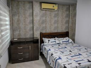 a bedroom with a bed and a wooden dresser with a bed sidx sidx sidx at Casa España in Sincelejo