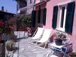 a group of chairs sitting outside of a pink building at Casa Violetta in Levanto