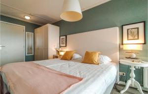 a bedroom with a white bed with a green wall at Beach Front Apartment In Cadzand-bad With Kitchen in Cadzand-Bad