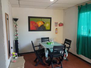 a dining room table with chairs and a painting of fruit at Casa CamiMar, Casa Amoblada solo para tí y tú familia in Santa Marta
