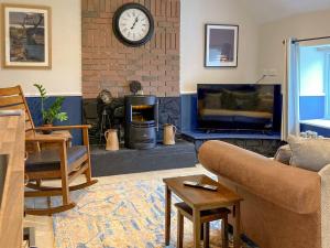 a living room with a couch and a fireplace at Taigh Violet Rose in Gramisdale
