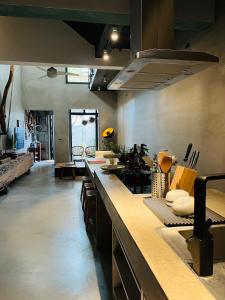a large kitchen with a counter top in a room at 隱室x迷路 Hermit Inn Hengchun in Hengchun