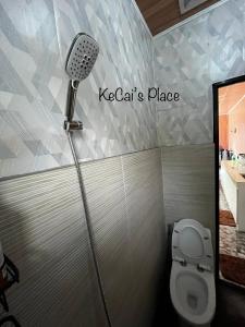 a bathroom with a shower with a toilet and a microphone at KeCai’s Place in Digos