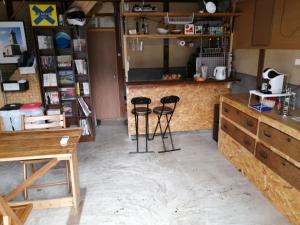 a room with two bar stools and a counter at kaeru Guest house in Takamatsu