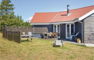 a blue house with a table and chairs in the yard at Holiday Home Syrenvej Skjern Ix in Skjern