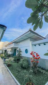 a white house with a garden in front of it at CERIA HOTEL at Alun Alun Yogyakarta in Yogyakarta