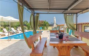 a patio with a table and chairs and a pool at Stunning Home In Marcana With Kitchen in Marčana