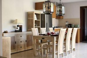 a kitchen with a wooden table and chairs in a kitchen at Tolgay Living Villas in Seminyak