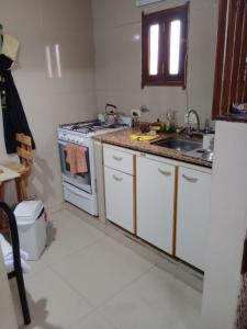 a kitchen with white cabinets and a sink and a stove at Casa de Jose in Santiago del Estero