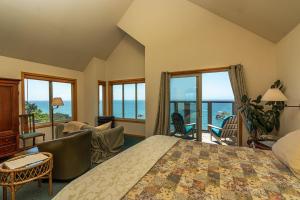 1 dormitorio con 1 cama grande y vistas al océano en Turtle Rocks Oceanfront Inn en Trinidad