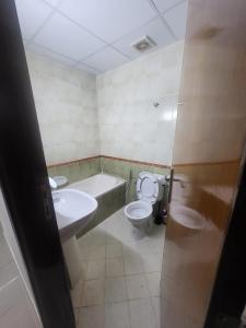 a bathroom with a sink and a toilet and a tub at Luxury 3 BHK family vacation home in Dubai