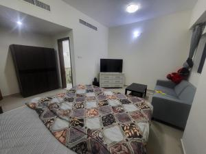 a bedroom with a bed and a couch and a television at Luxury 3 BHK family vacation home in Dubai